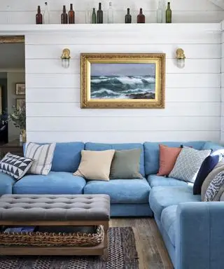 Sala de estar com sofá modular azul e almofadas coloridas em nova construção costeira da Cornualha