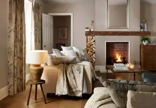 Salón rural de estilo rústico con chimenea y sofá.