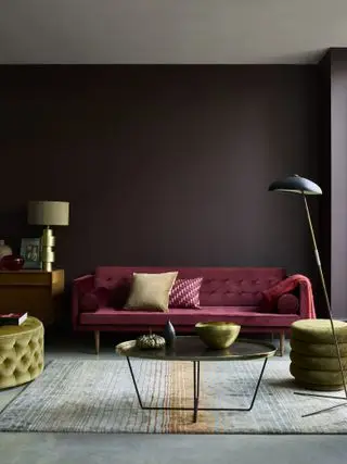 Ideen für Wohnzimmerfarben in dunklem Schokoladenbraun, mit einem pflaumenfarbenen Samtsofa, grünen Samthockern und Metallakzenten.