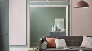 Ideen für die Bemalung eines Nischen-Wohnzimmers, dargestellt in Mintgrün in einem blassrosa Farbschema mit grauem Sofa.