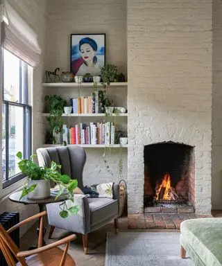 Herbstliche Wohnzimmerdekoration mit Kamin, Backsteinmauer und Regalen