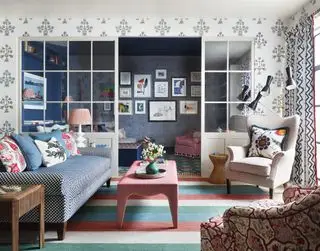 sala colorida com divisória de vidro e tapete listrado