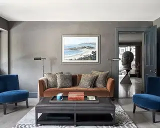 Salon gris avec canapé marron et chaises bleues