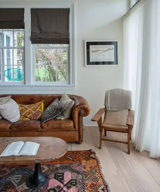 Salon neutre avec chaise en bois et canapé en cuir