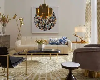 Jonathan Adler viser hvordan du planlegger stuebelysning, med kremsofa og statement gullpendellys.