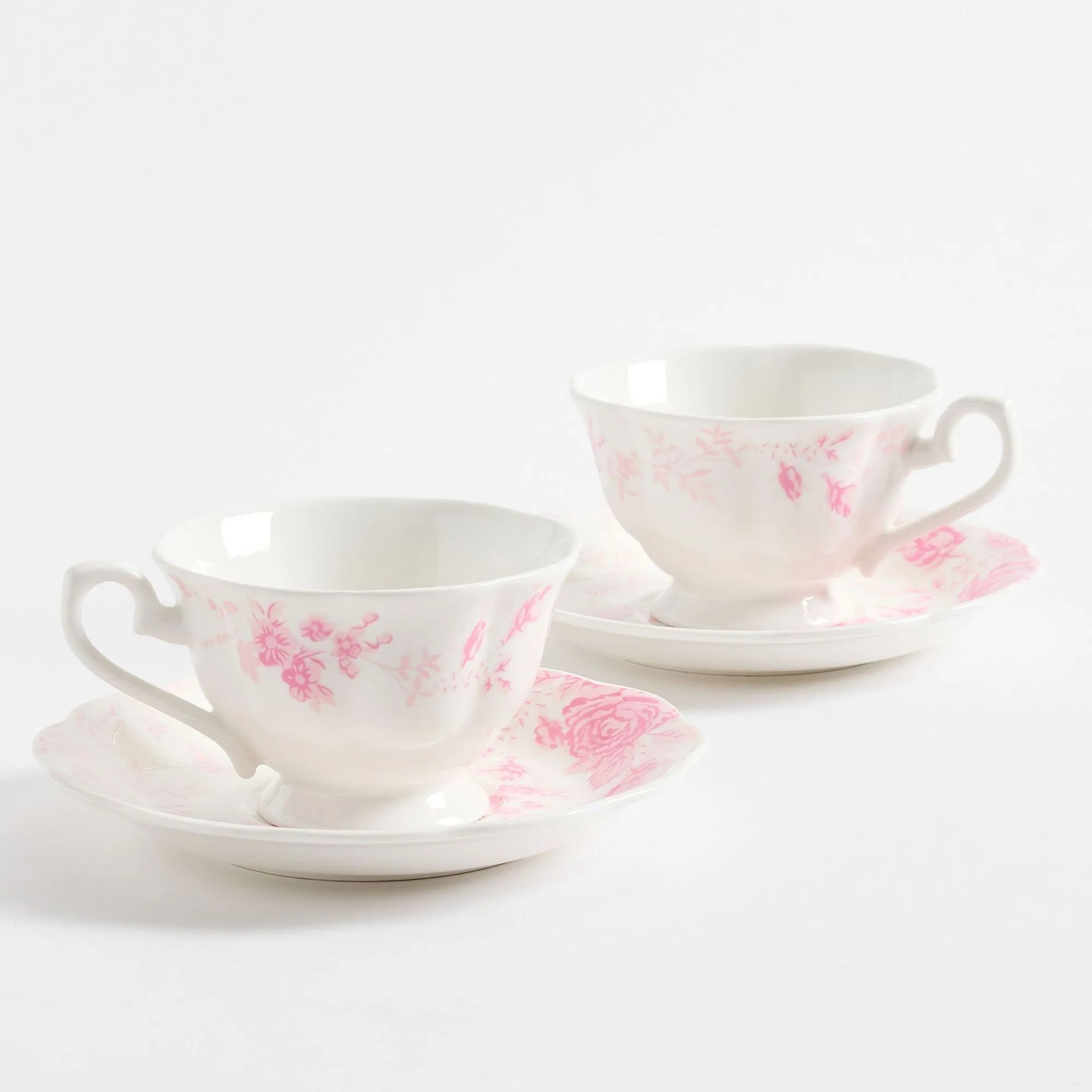 Tazas de té florales blancas y rosas con platillos.' loading='lazy' title=