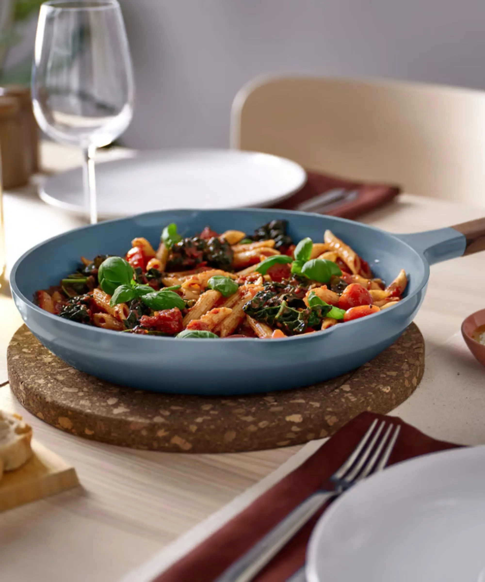 Tyrkysová pánev na korkové trojnožce na dřevěném jídelním stole' loading='lazy' title=