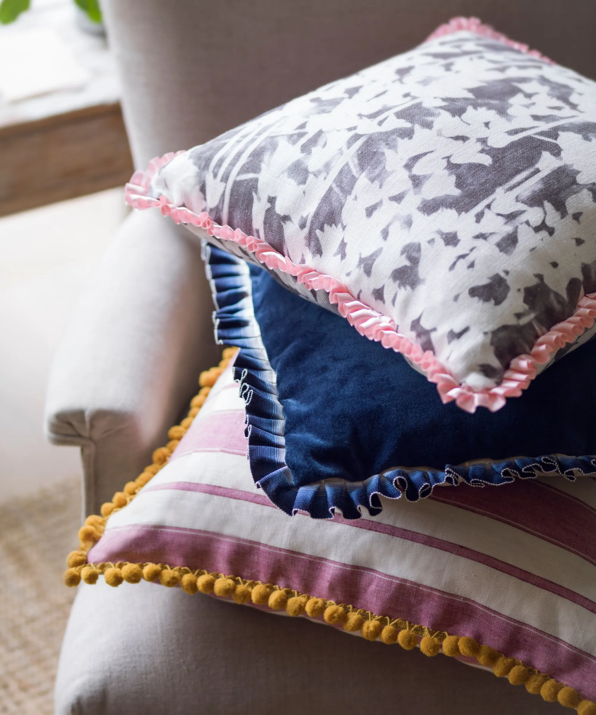 Coussins colorés empilés sur une chaise' loading='lazy' title=