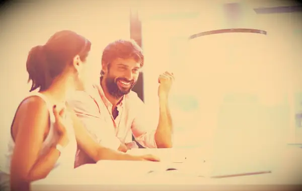 Co-workers in an office laughing and having fun.