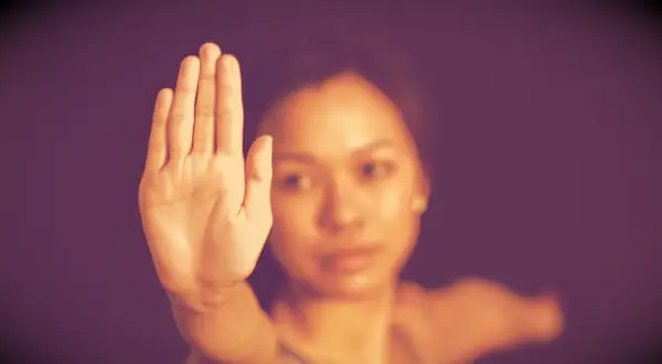 An image of a woman making a stop sign with her hand.