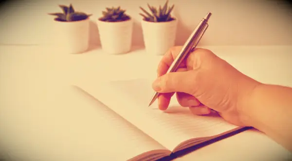 A man writing in a notebook.