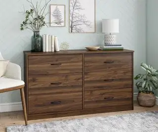 Walmart kommode med nipsgenstande på toppen mod en andeæg blå soveværelsesvæg.