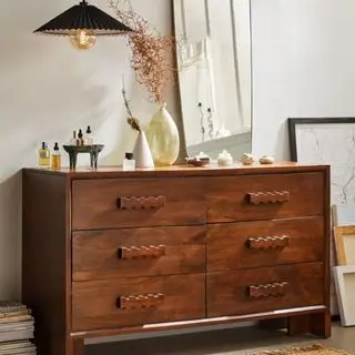 Urban Outfitters Alonzo Kommode med nipsting på toppen mod en hvid væg.
