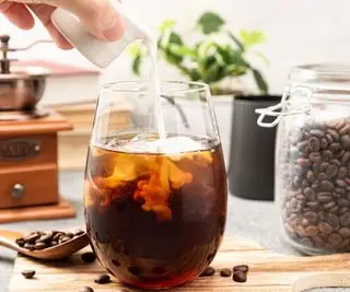 kald kaffe på en benkeplate med melk som helles i
