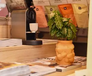 Nespresso kaffetrakter på et bord med blader rundt