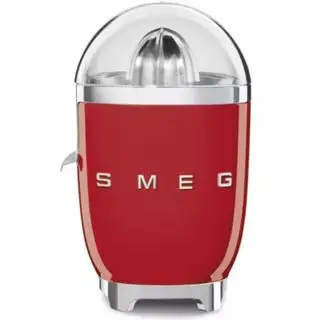 Mini odšťavňovač Magic Bullet na bílém pozadí s plným šálkem pomerančového džusu a jeho čisticím nástrojem.
