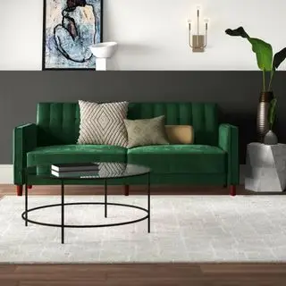 Canapé convertible Wayfair Perdue en velours contre un mur gris.