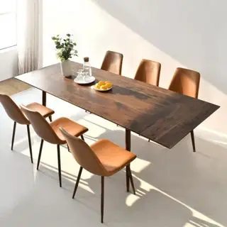 Table de salle à manger extensible Wayfair Bende et chaises contre un mur blanc.