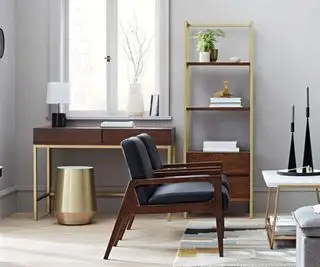 Un salon gris avec banquette, étagères et bureau.