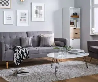 Un ensemble de salon gris avec un jeté et un tapis douillets.