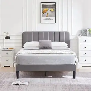 Cadre de lit plateforme Wayfair Auxter contre un mur gris.