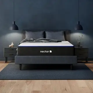 Matelas en mousse à mémoire de forme Nectar sur un lit contre un mur sombre.