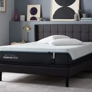 Un matelas Tempur-Adapt sur un lit contre un mur gris.
