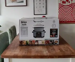 Díly Ninja Foodi PossibleCooker Pro na jídelním stole; rošt na pečení a hrnec na pomalé vaření