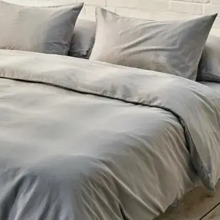 Graue Bettwäsche auf dem Bett im neutralen Zimmer