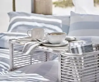tazza da caffè hampton con una ciotola su un mini tavolo esterno su biancheria da letto blu e bianca