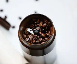 Un molinillo de café con granos de café en su interior.