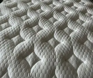 Um copo d'água em um colchão Nectar Memory Foam.
