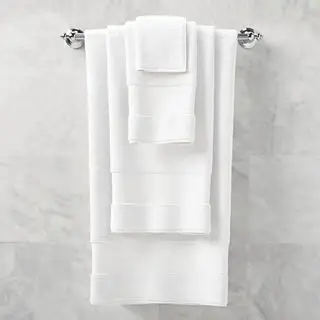 Badetücher aus der Frontgate Resort Collection in Weiß, die an einer Badezimmerwand hängen.
