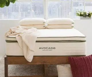 Cubrecolchón orgánico de aguacate sobre una cama.