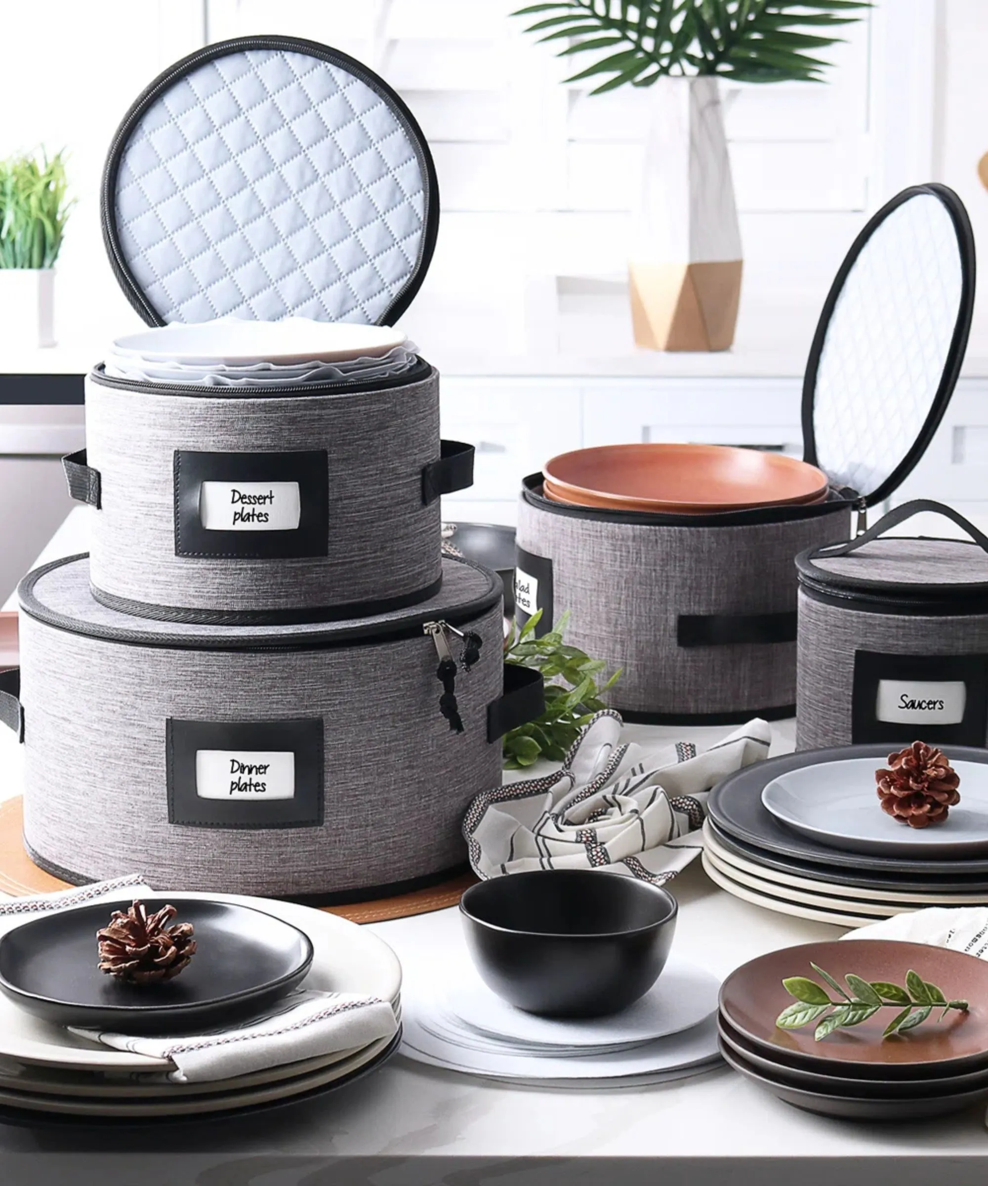 Stabler med oppbevaringsposer for servise med grå hardt skall med etiketter omgitt av servise.' loading='lazy' title=