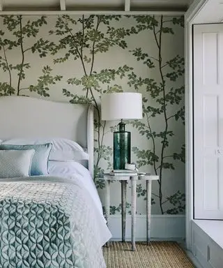 Papel de parede com estampa botânica, ideias aconchegantes para quartos com cama estofada.
