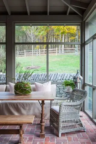 Wintergarten mit Ziegelboden und Terrassenmöbeln