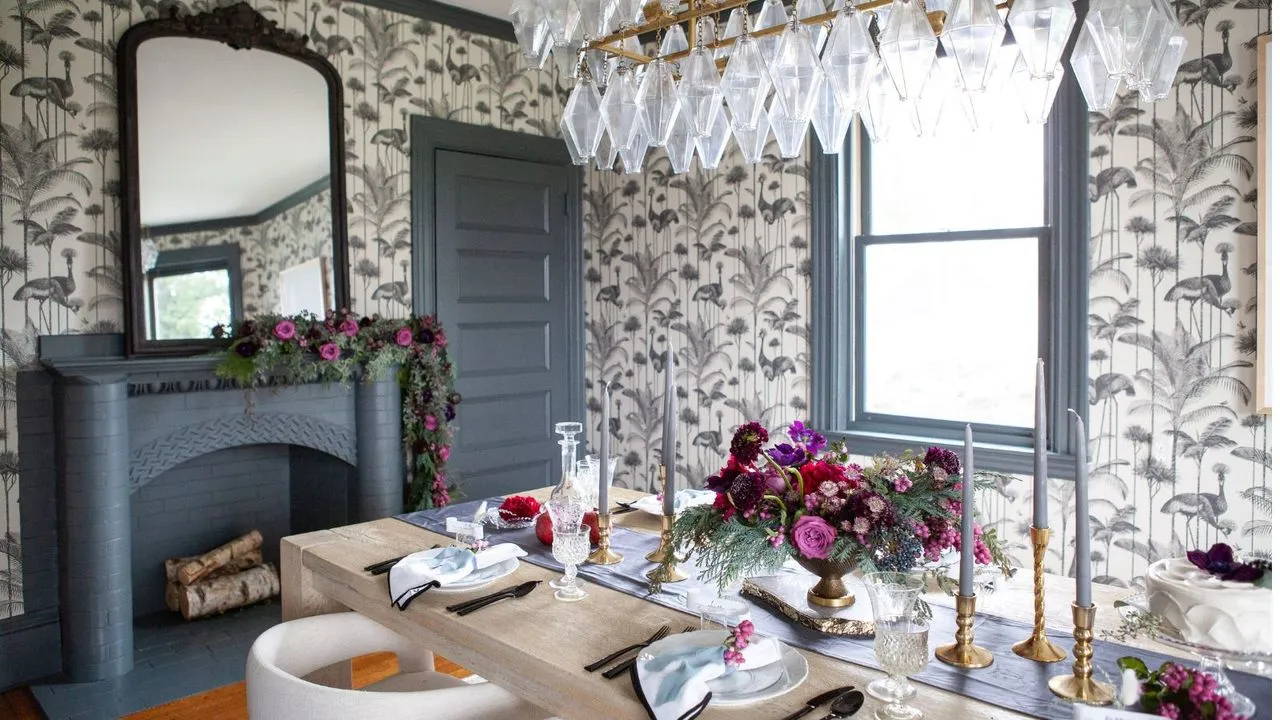 Comedor con un intrincado papel tapiz, repisa y lámpara de techo de vidrio, así como puertas de madera pintadas, marcos de ventanas, marco de repisa en tono azul medio tiza' loading='lazy' title=