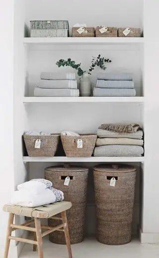Soluzioni di archiviazione semplici ma intelligenti. Coperte, asciugamani e cestini nell'alcova della camera da letto.