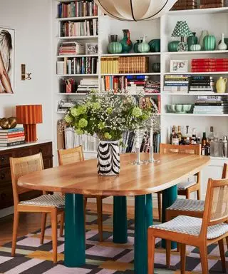 Una sala da pranzo con una libreria piena
