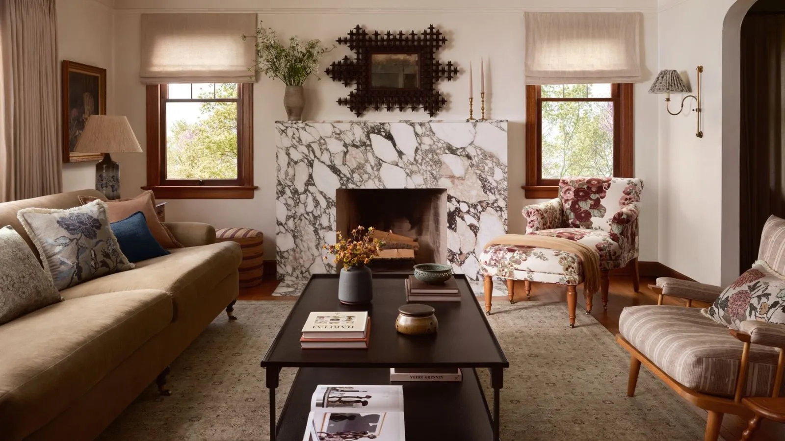 Designer Collaboration Round-Up Hero Image of the Heidi Caillier X Joon Loloi teppesamarbeid skutt i en eklektisk vintage stue med et stort teppe og marmorpeis' loading='lazy' title=