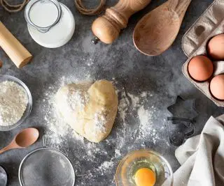 pasta frolla su una superficie con utensili attorno