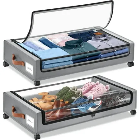 Due borse portaoggetti in tessuto grigio per sotto il letto su ruote in plastica nera con coperchio trasparente. Scarpe nel sacchetto inferiore e magliette piegate in quello superiore.' loading='lazy' title=