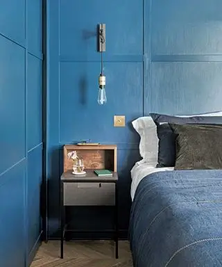 dormitorio con cama, almohadas y mesita de noche