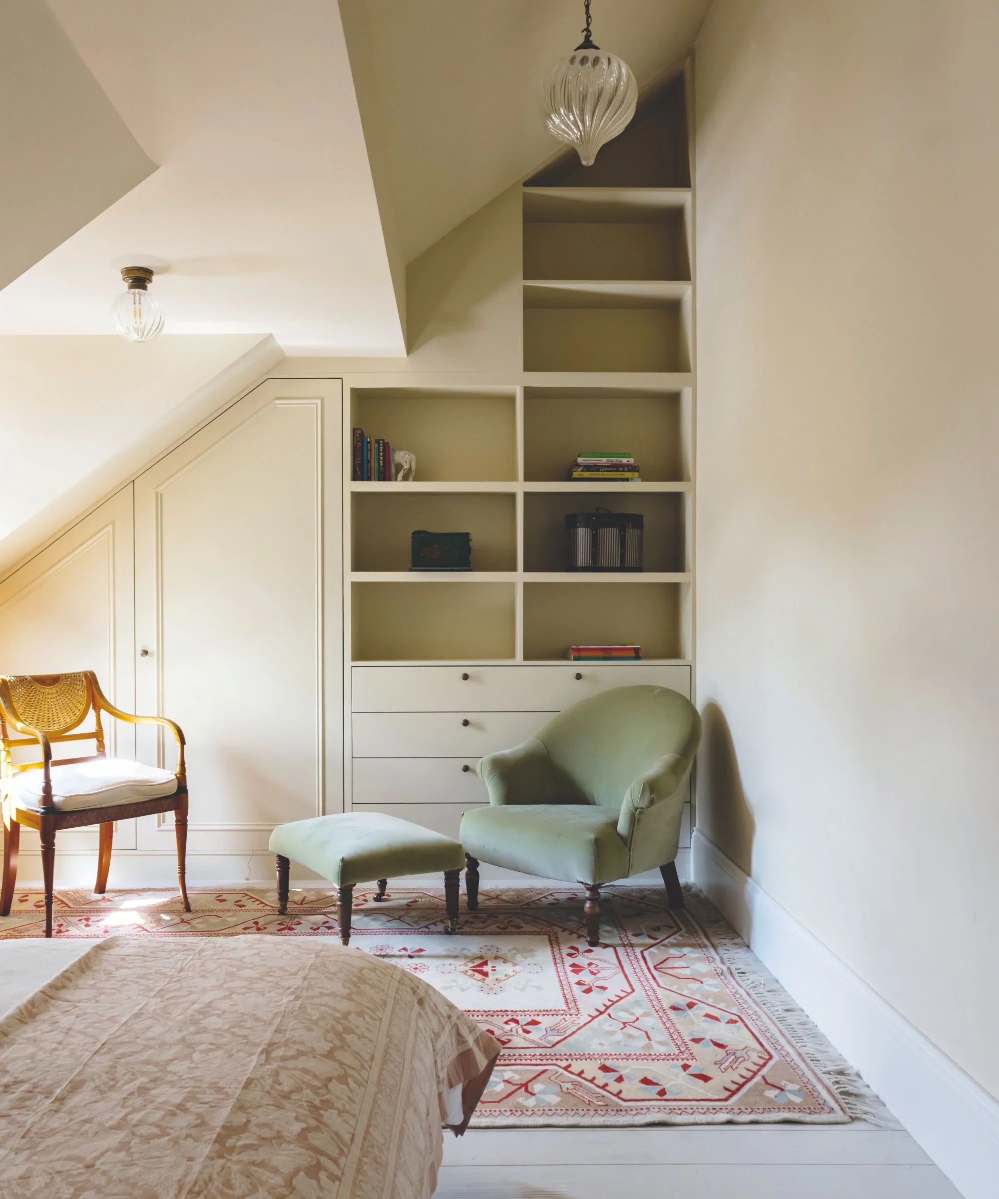 חדר שינה בעליית גג עם מדפים מובנים וארונות לבד הקיר האחורי.' loading='lazy' title=