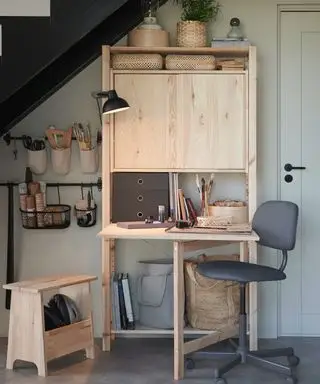 Un bureau dépliant en bois avec meuble de rangement intégré