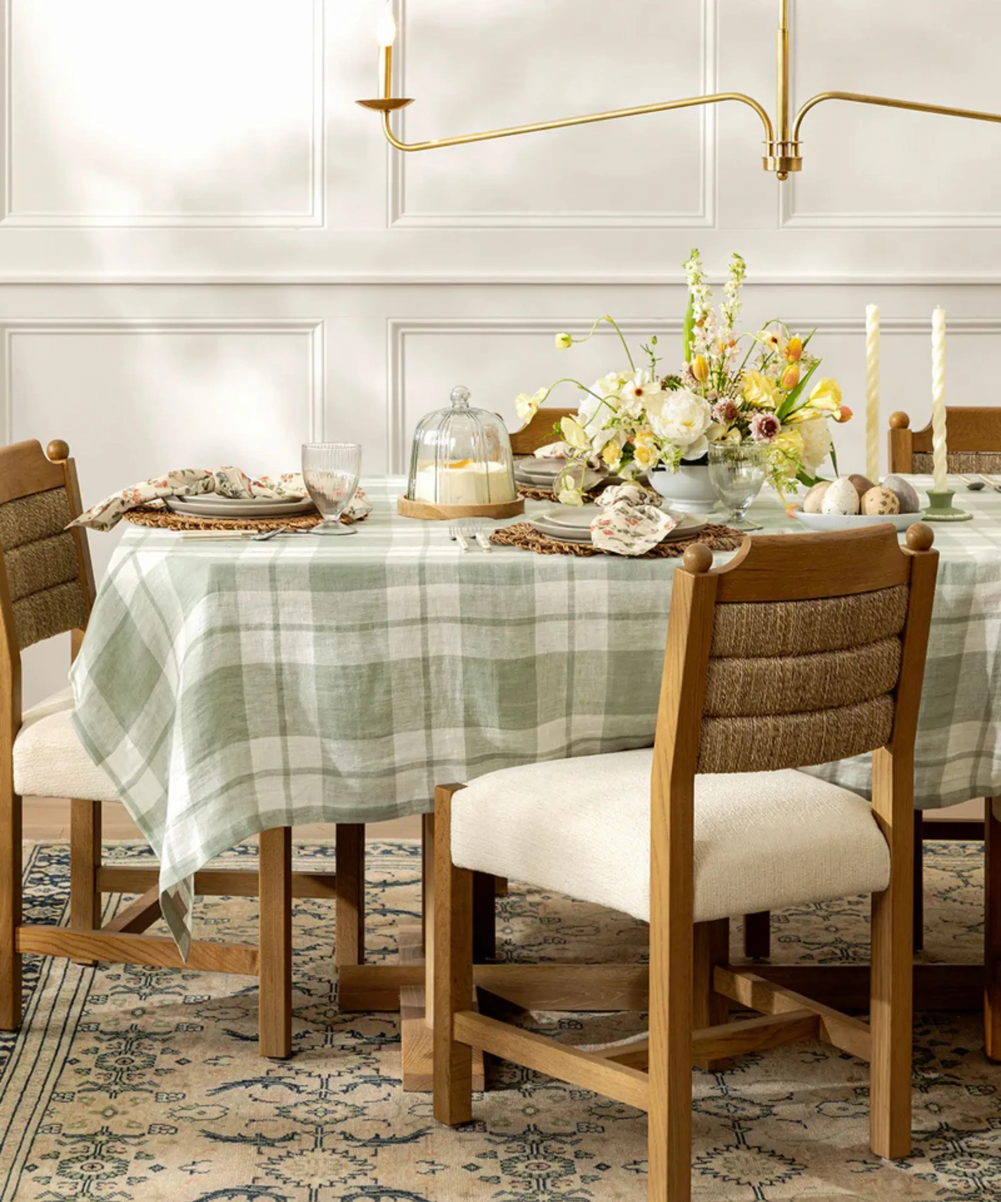 AUne table de Pâques décorée d'une nappe à carreaux bleu clair et de vaisselle assortie' loading='lazy' title=