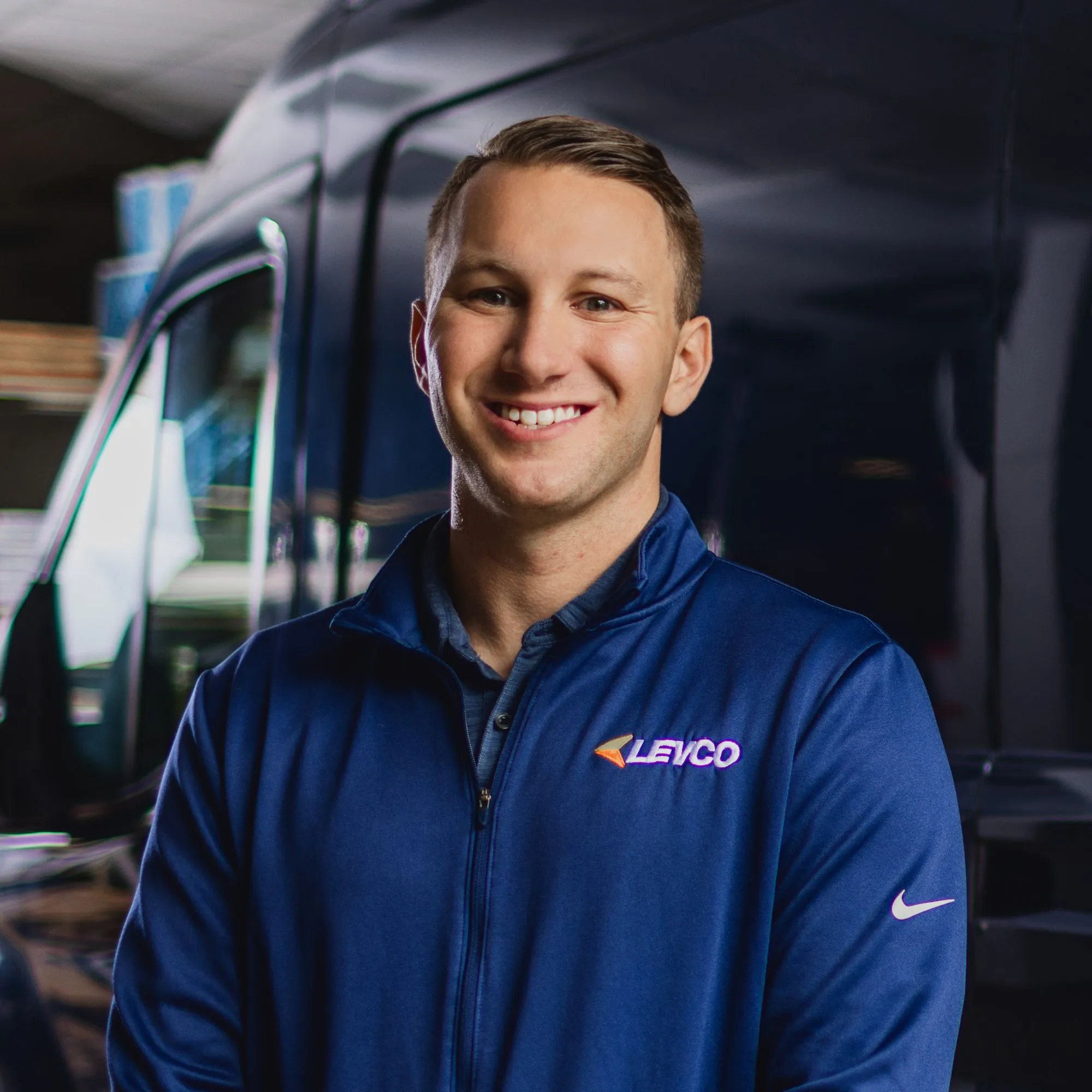 Obrázok Scotta Levenea - muža v modrom fleece, ktorý sa usmieva pred kamerou stojaceho pred modrou dodávkou' loading='lazy' title=