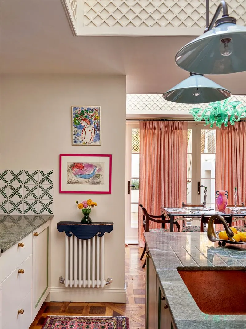 Dekoratívny tmavomodrý kryt na radiátor vo vnútri hravej kuchyne' loading='lazy' title=