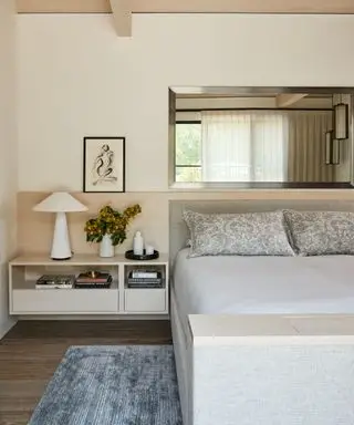 Neutrales Schlafzimmer mit verstecktem Fernseher im Fußende des Bettes